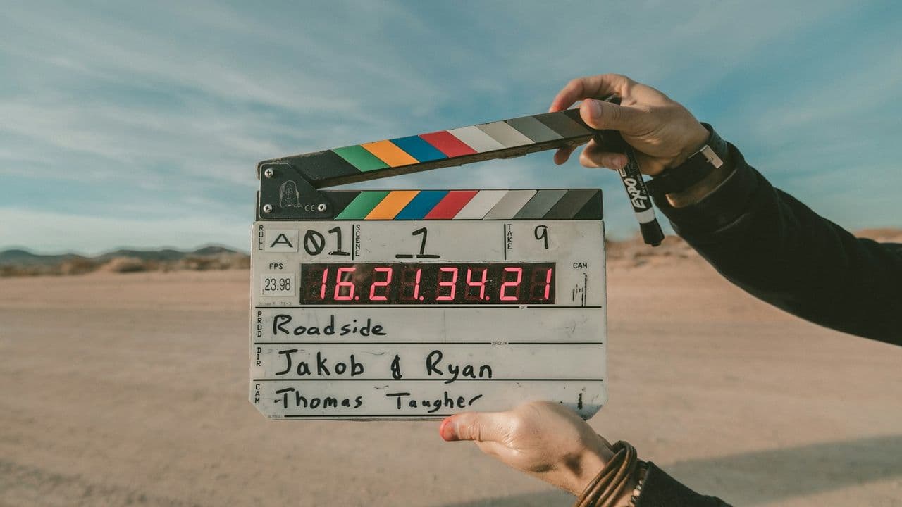 Claqueta de cine sostenida frente a un paisaje