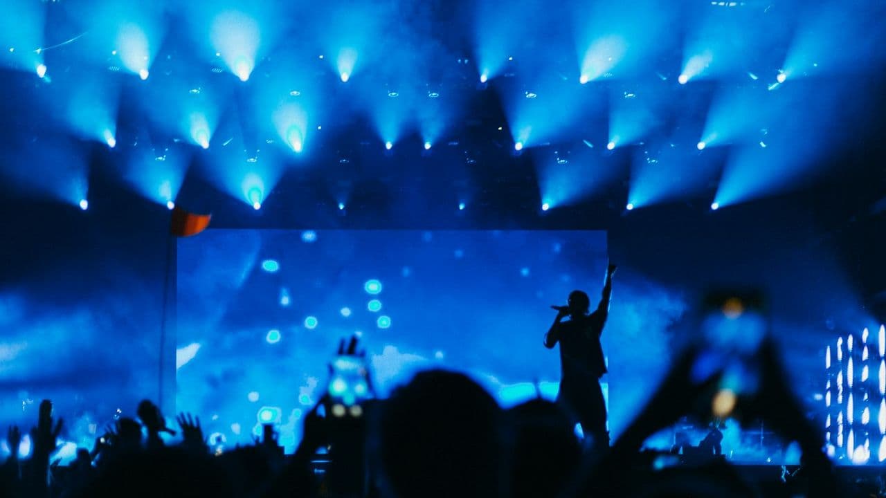 Siluetas del público ante un escenario con luces